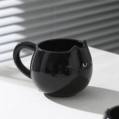 Adorable hand - painted cat - shaped ceramic mug, perfect for coffee or tea.